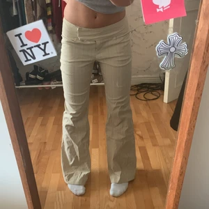 Beiga lågmidjade kostymbyxor - Asfina lågmidjade beiga kostymbyxor med omlott knäppning liksom🙃🙃sitter asbra å är bootcut, perfekt längd för mig som är 160cm å nyskick skick:)))står ingen storlek men passar bra på mig som har w26