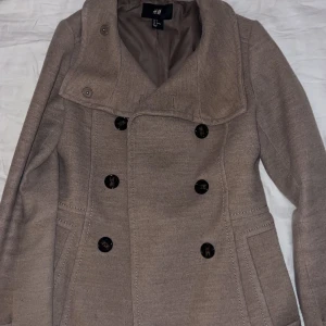 Beige kappa  - Säljer världens finaste beiga kappa från H&M😍Den har knappar på båda sidorna och jag säljer den för att den tyvärr har blivit för liten på mig😩Den är i bra skick, skriv privat om du undrar något eller vill ha fler bilder ❤️