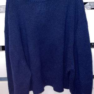 En marinblå stickad tröja i en litelite kortare modell men ej en croppad. Storlek 36 ifrån Asos Design, passar även 34.
