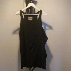 Svart klänning 1 - Fin klänning från Acne, liten slits bak samt ”volang” på ena sidan.