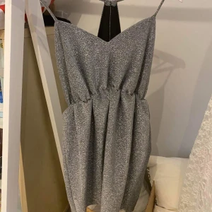 Jättefin klänning i glittrande silver  - Fin klänning från Nelly storlek medium men liten. Använd en gån. 