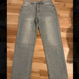 Ljusblå raka jeans i storlek M - Säljer ett par ljusblå jeans med raka ben och klassisk femficksdesign. Jeansen är tillverkade i 90% bomull och har en skön, lite loose passform. Perfekta för dig som gillar en avslappnad stil och vill ha ett par jeans som funkar till det mesta.