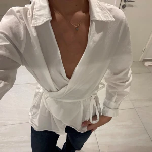 Vit Omlottblus - Super söt vit omlottblus i strl S som både går att klä upp eller klä ned. Man knyter själv i ryggen så storleken är väldigt anpassningsbar!