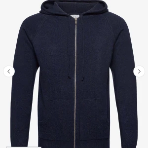 Mörkblå hoodie i kashmir från Davida - Mysig mörkblå hoodie från Davida i lyxig kashmir. Tröjan har dragkedja, huva med snörning och två fickor framtill. Perfekt för dig som vill ha en stilren och bekväm look med premiumkänsla. Nypris 2800