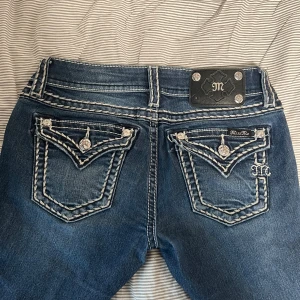 Miss Me bootcut jeans - Snygga blå låg midjade jeans från Miss Me! Säljer för att de int ekonomer till andvändning tyvärr🫶🏼En detalj där bak har strilat av och samma där nere är det lite slitage men inga hål❤️ köptes för 2300kr!