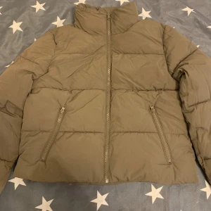 Olivgrön pufferjacka från H&M - Säljer en olivgrön pufferjacka från H&M i storlek S. Jackan har hög krage, två snedställda fickor med dragkedja och hel dragkedja framtill. Perfekt för kyliga dagar och riktigt skön att bära. Enkel och stilren design som passar till det mesta.