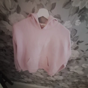 Ljusrosa hoodie från Gina Tricot - Säljer en ljusrosa hoodie från Gina Tricot i storlek XXS. Tröjan har en klassisk huva, magficka och är långärmad. Perfekt för dig som gillar en enkel och stilren look. Mjuk och skön, passar till många outfits.