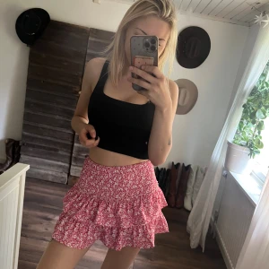 Rosa blommiga volangkjol - Supersöt kjol med volanger i rosa och vitt blommönster. Även som shorts på insidan. Perfekta för sommaren och riktigt sköna att bära. Materialet känns lätt och luftigt. Väldigt stretch, passar xs-m 