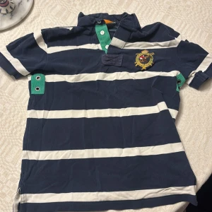 Ralph Lauren Piké custom fit - Säljer nu min piké då jag växt ur den, storleken är medium men passar small rätt bra också. Fick den av min far, köpt för antagligen 25+ år sedan men i väldigt bra skick under de omständigheterna.