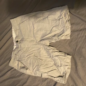 Beige shorts från Quiksilver - Snygga beige shorts från Quiksilver med klassisk passform. De har två sidofickor, två bakfickor och stängs med knapp och dragkedja. Perfekta för varma dagar och har en stilren look som funkar till det mesta.