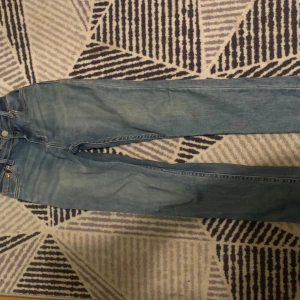 Levi's 501 ljusblå jeans - Klassiska Levi's 501 jeans i ljusblå denim med raka ben och femficksdesign. Byxorna har knappgylf och den ikoniska läderpatchen bak i midjan. Perfekta för dig som gillar en tidlös och avslappnad stil.