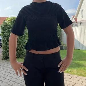 Svart croppad topp med volangkant - Skit snygg topp, endast använd en gång🩷slutsåld hos Gina 
