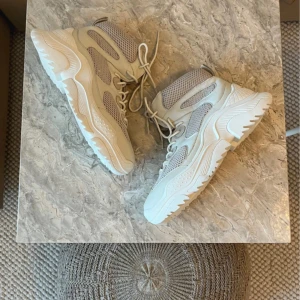 Jeffery Campbell boots  - Säljer ett par chunky boots i vit färg med coola meshpaneler och grov sula. Skorna har snörning framtill och en riktigt modern vibe. Perfekta för dig som gillar streetstyle och vill sticka ut. Materialmix av läder och mesh ger både stil och komfort.