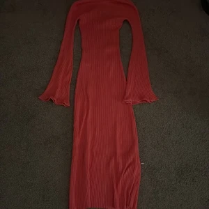 Rosa ribbad långklänning från NA-KD - Säljer en superfin rosa långklänning från NA-KD i ribbat material. Klänningen har långa ärmar och en snygg v-ringning i ryggen. Perfekt för när man vill vara bekväm men samtidigt lite finare i vardagen. Storlek xxs men stretchigt material så passar xs också 