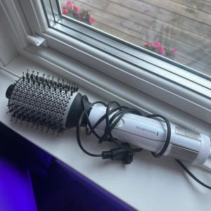 Remington varmluftsborste - Remington varmluftsborste för enkel styling och volym. Rund borste med keramisk yta och flera värmelägen. Synligt använd men i gott skick, fungerar utmärkt. Perfekt för att skapa volym och släta ut håret snabbt.