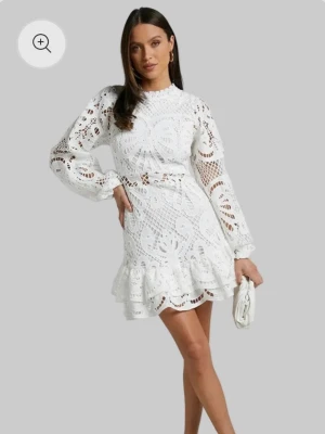 Vit spetsklänning med volang - Superfin vit kortklänning i spets och volang nertill. Den är aldrig använd💕💕Klänningen har broderat blommönster och dragkedja i ryggen. Perfekt som studentklänning!💕💕💕den är i Stolek M och beställd från bikinimode