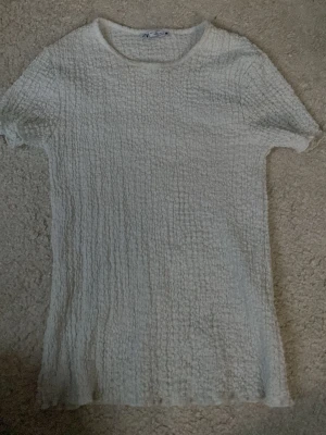 Vit ribbad t-shirt från Zara - Säljer en vit t-shirt från Zara i storlek S. T-shirten har ett ribbat och texturerat tyg!