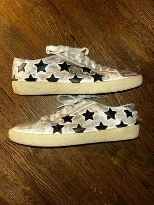 Unika Saint Laurent skor - Säljer ett par Saint Laurent skor i storlek 42. Skulle säga att skick är 8/10, det ändå är att det är lite lossnat på fronten av den vänstra skon (se bild). Box ingår samt äkthetsbevis! Hör av er vid frågor!