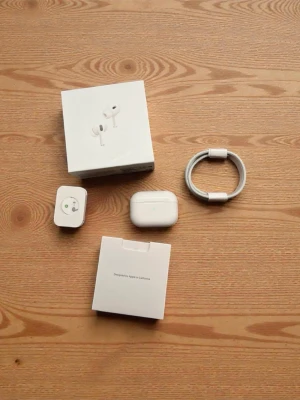 AirPods Pro (2nd generation ANC) - Apple AirPods Pro (2nd generation) med MagSafe-laddningsetui (USB-C). Komplett med originalförpackning, extra öronkuddar och laddkabel. Produkten ser ut att vara i nyskick utan synligt slitage eller defekter. Aktiv brusreducering och hög ljudkvalitet.