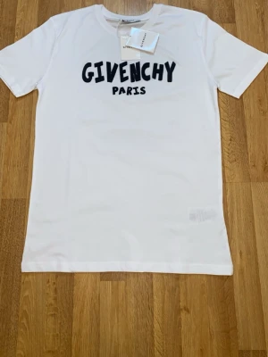 Vit t-shirt  med tryck - Säljer en clean vit t-shirt  med svart 3D-tryck på bröstet. Klassisk rund hals och korta ärmar. Materialet är mjuk bomull som känns skönt mot huden. Perfekt för dig som gillar exklusiva streetwear-vibes.