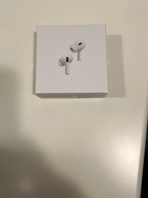 AirPods Pro (2nd Generation) MagSafe USB-C - Säljer ett par AirPods Pro (2nd Generation) med MagSafe-laddningsetui och USB-C. Produkten är i originalförpackning och ser ut att vara i nyskick. Perfekt för dig som vill ha aktiv brusreducering och hög ljudkvalitet. Inga synliga defekter eller slitage.
