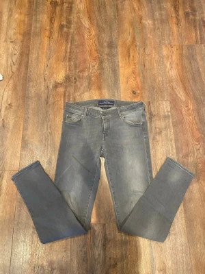 Gråa jeans från Jacob Cohen - Snygga grå jeans från Jacob Cohen med smal passform och klassisk femficksdesign. Jeansen har dragkedja i gylfen och diskret logotyp på bakfickan. Materialet är mjukt jeans-tyg som sitter riktigt bra och ger en modern look. Modellen Jocelyn.