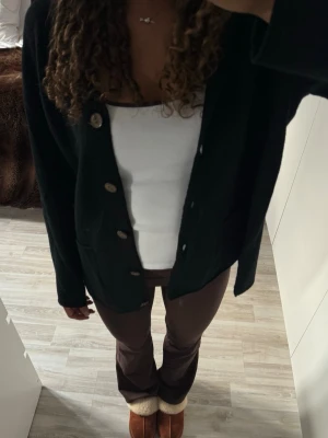 Svart kofta med knappar - En svart kofta med stora knappar framtill och två fickor. Köpt från Gudrun Sjödén o storlek m  