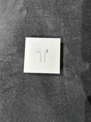 Apple AirPods (1nd Generation) - Säljer ett par Apple AirPods (1nd Generation) i originalförpackning. Trådlösa hörlurar med laddningsetui. Produkten ser ut att vara i gott skick med endast mindre spår av användning på etuiet. Perfekt för dig som vill ha smidig och trådlös musikupplevelse. Den högra funkar bra men inte 100%, paket följer ej med