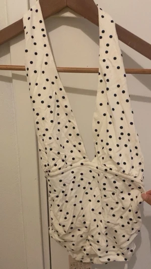 Prickig vit omlott linnetopp XS - Säljer en så gullig vit backless topp med v-ringning och svarta prickar