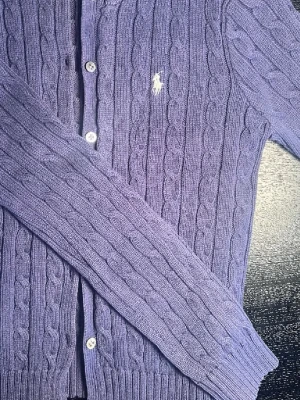  Polo Ralph Lauren stickad kofta - Skick: 6:10. Nypris: 2400kr. Säljer för 1049kr. Jättefin ribb stickad marinblå kofta från Polo Ralph Lauren. Koftan har knappar fram och en liten broderad häst på bröstet. Väldigt elegant, perfekt för dig som gillar old money stilen!!