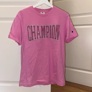 Rosa Champion t-shirt med broderad logga - Champion t-shirt i storlek small som säljs i fint skick pga att den inte kommit till användning