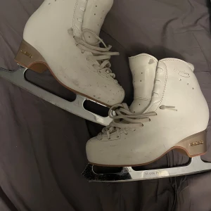 Vita edea overture konståkningsskridskor. - De är använda i 1,5 terminer och är storlek 240 som motsvarar ungefär storlek 37. De är ett par vita konståkningsskridskor från Overture med Mark IV Ultima skena. 