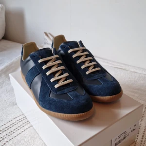 Maison margiela GATS - Nu säljer jag ett par stilrena mörkblåa GATS i storlek 44, skicket är 9/10, kvitto, boxen och dustbags ingår, skriv vid minsta lilla fundering och lägre pris vid snabbaffar.