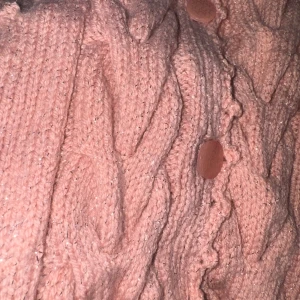 Superfin handstickad rosa kofta i mjukt garn med glittrande tråd! - Superfin handstickad rosa kofta i mjukt garn med glittrande tråd! Den har ett vackert flätmönster framtill, små fickor, och fina knappar – plus en extra knapp insydd på insidan. Perfekt att bära över klänningar, skjortor eller toppar under höst och vinter.  🧵 Storlek: ungefär M/L 🎀 Färg: ljusrosa med glittertråd 🪡 Skick: Ny, oanvänd, handgjord med kärlek      #handstickad #kofta #rosa #glitter #vintedfind #stickat #handmade