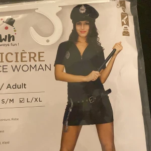 Blå polis klänning med bälte - L/XL men sitter som en M. Säljer en marinblå kort polis klänning med dragkedja framtill och tillhörande bälte med detaljer. Klänningen har korta ärmar och en v-ringad hals. Perfekt för temafest eller maskerad! Aldrig använd, säljer för jag köpte fel storlek. Priset kan diskuteras. 