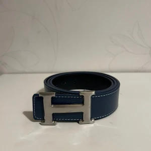 H Bälte Blå - Helt nya & högkvalitativa bälten till låga priser! Välj bland olika märken, mönster och färger. Vi fraktar din order så snabbt som möjligt och vi ser till att ditt paket är säkert packat under frakt 🚚 
