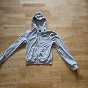 Beige hoodie med dragkedja Gina Tricot XS. - Snygg beige hoodie från Gina Tricot i storlek XS. Tröjan har huva, långa ärmar och en cool dragkedja med rund metallring. Praktiska fickor framtill och mjukt material som känns skönt mot huden. Perfekt för chill dagar eller när du vill ha en enkel och stilren look.