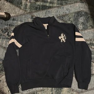 IFK Göteborg Half Zip hoodie - PRIS GÅR ATT DISKUTERAS. Säljer denna half zip då den blivit för liten, den är endast använd ett fåtal gånger på matchdag då jag snabbt växte ur den. den är köpt från blåvittshoppen år 2021 om jag minns rätt. Och har nu legat i garderoben sedan dess!