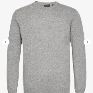 Oscar Jacobson  - En klassisk grå stickad tröja med rund halsringning och långa ärmar. Perfekt för lager-på-lager och enkel att matcha med jeans eller chinos. Mjuk och skön känsla, passar dig som gillar stilren och enkel design.