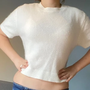 Vit stickad tröja från Gina Tricot - Supermjuk vit stickad tröja från Gina Tricot med korta ärmar och ribbade kanter vid hals, ärmslut och nederkant. Enkel och clean design som är lätt att matcha med allt. Perfekt för lager-på-lager eller som den är under svalare dagar. Säljer för att jag inte gillar hur den sitter på. 👍