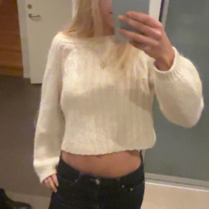 Croppad stickad tröja från Zara - Supermysig croppad stickad tröja från Zara i en ljus beige färg. Tröjan har ribbad struktur, rund hals och långa ärmar. Perfekt för dig som gillar en chill och trendig look. Passar dig som vill ha en lite loose fit.