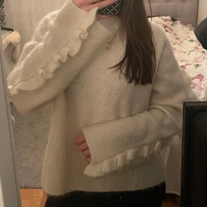 Arket stickad tröja - Säljer denna volangtröja i mohair och ull från arket! Jätte bra skick, endast lite sminkfläck på insidan av tröjan!