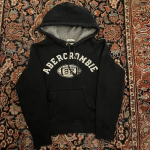 Vintage Abercrombie and fitch hoodie - Riktigt snygg vintage Abercrombie and fitch hoodie, denna har snygga vi Tage detaljer och är extremt trendig just nu. Bra skick. Mått: Bredd: 48cm Längd: 58cm