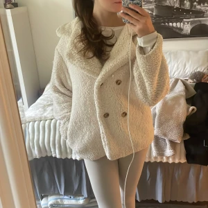 Krämvit teddyjacka med stora knappar - Teddyjacka i krämvitt. Säljer billigt då den är från Shein och mer hjälper som en tunn jacka över på vår eller kyliga sommardagar. 