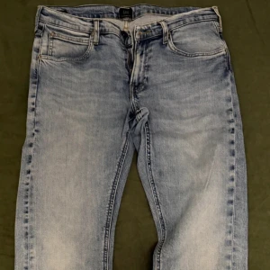 Lee ljusblå straight jeans W31 L30 - Snygga ljusblå jeans från Lee med klassisk femficksdesign och tydlig tvättad look. Modellen har raka ben och normal passform, med Lee-logga på bakfickan. Perfekt för dig som gillar en chill och tidlös stil.