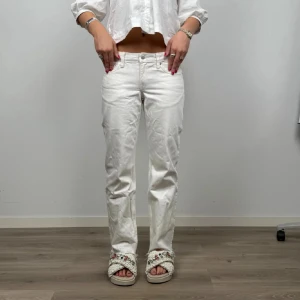 Vita raka jeans från Levis - Snygga vita jeans från Levis med klassisk rak passform och normal midja. Byxorna har fem fickor, knapp och dragkedja framtill. Perfekta för dig som gillar en clean och fräsch look. Passar till sneakers eller sandaler.