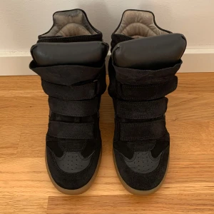 Svarta Isabel Marant sneakers med kilklack - Säljer Isabel Marant skor i jättefint skick. På sista bilden ser sulan sliten ut men känner man så är det lent och fint och det känns inte alls när man har på sig skorna 💕
