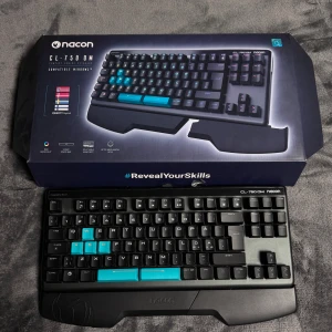 Nacon CL-750OM Compact Gaming Keyboard - Nacon CL-750OM är ett kompakt gamingtangentbord med optiska mekaniska switchar, RGB-bakgrundsbelysning och utbytbara handstöd. QWERTY-layout och dedikerade blå gaming-tangenter. Mycket fint skick, komplett med originalkartong och klistermärken. Jag har inte använt den så mycket, eftersom jag mest jobbar på min laptop.