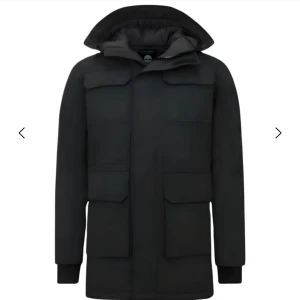 Svart parkajacka från Paul Smith - Säljer en svart parkajacka från Paul Smith med stor huva, fyra stora fickor framtill och quiltat foder. Jackan är lång, har dragkedja och knappar framtill samt ribbade muddar vid ärmslut. Perfekt för kalla dagar och riktigt snygg stil. Original pris ca 3000kr