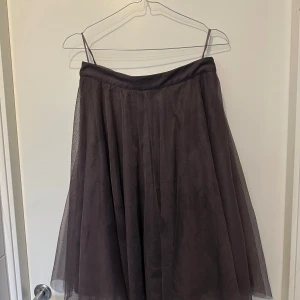 Mörklila tyllkjol från Esprit. Perfekt till Halloween!! - Säljer en snygg mörklila midikjol från Esprit i tyll. Kjolen har ett voluminöst fall och bred linning i midjan. Perfekt för dig som gillar en luftig och elegant look. Stängs med dragkedja i sidan.